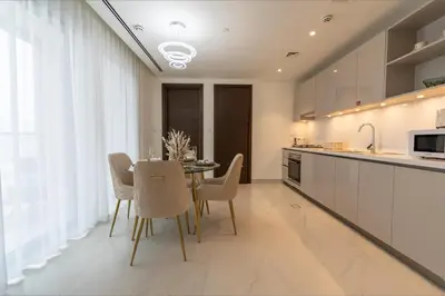 a dining room with a table and chairs in a kitchen at Modern 1BR in Creek Vistas Grande, Burj Khalifa View in Dubai