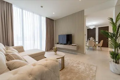a living room with a couch and a tv at Modern 1BR in Creek Vistas Grande, Burj Khalifa View in Dubai