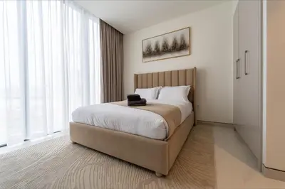 a bedroom with a large bed with a large window at Modern 1BR in Creek Vistas Grande, Burj Khalifa View in Dubai