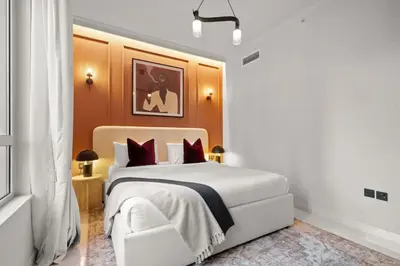 a bedroom with a large white bed with red pillows at 2-Bedroom Apartment with Full Burj Khalifa & Opera House Views Just 9 Min Walk to Dubai Mall! in Dubai