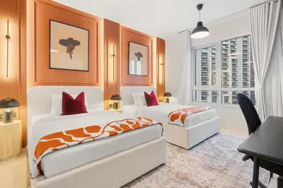 a bedroom with two beds and a desk and a window at 2-Bedroom Apartment with Full Burj Khalifa & Opera House Views Just 9 Min Walk to Dubai Mall! in Dubai
