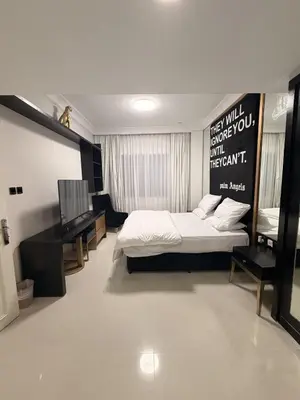 a bedroom with a bed and a television in it at 1 BR in Mall St in Dubai