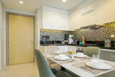 a kitchen with a table with chairs and a counter top at Elegant Sunset View 3BHK 7pax in Dubai