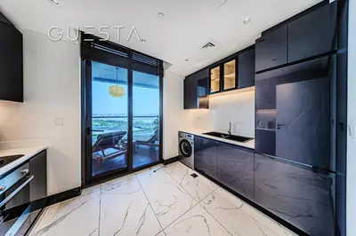 a kitchen with black cabinets and a view of the ocean at Terraces Marasi Drive, Business Bay in Dubai