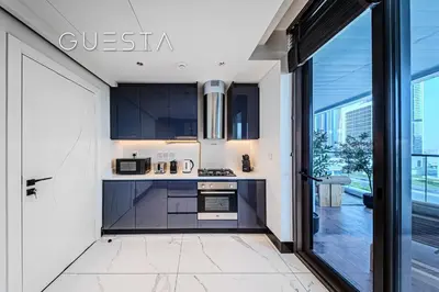 a kitchen with black cabinets and a large window at Terraces Marasi Drive, Business Bay in Dubai