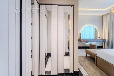 a bedroom with a bed and a room with a mirror at Terraces Marasi Drive, Business Bay in Dubai