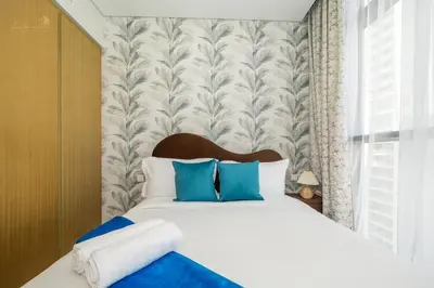 a bedroom with a large bed with blue pillows at Classic Canal View 2 Bhk 6pax in Dubai