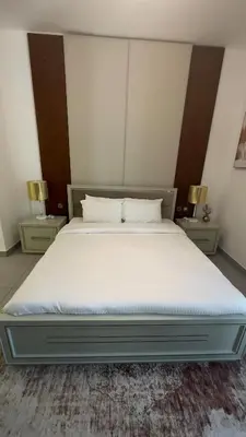 a bedroom with a large bed with two night stands at Royal bay Azizi Palm Jumeirah in Dubai