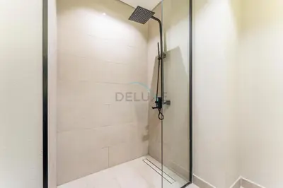 a shower with a glass door in a bathroom at Community Views Studio Near Nad Al Sheba Gardens with Balcony, MAG 980, Mohammad Bin Rashid by Deluxe Holiday Homes in Dubai