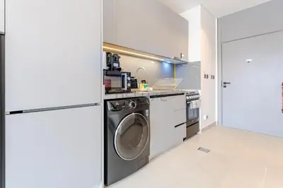 a kitchen with a washing machine and a washer and dryer at Community Views Studio Near Nad Al Sheba Gardens with Balcony, MAG 980, Mohammad Bin Rashid by Deluxe Holiday Homes in Dubai