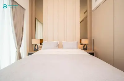 a bedroom with a large white bed with two lamps at Blue Breeze - Luxury Apartment in Downtown in Dubai