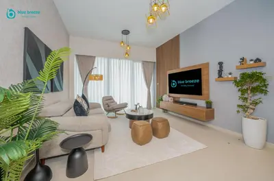a living room with a couch and a tv at Blue Breeze - Luxury Apartment in Downtown in Dubai