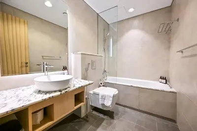 a bathroom with a sink and a bath tub at New Luxury 2 Bedroom with Burj Khalifa View & Spectacular Rooftop Infinity Pool Bar in Dubai