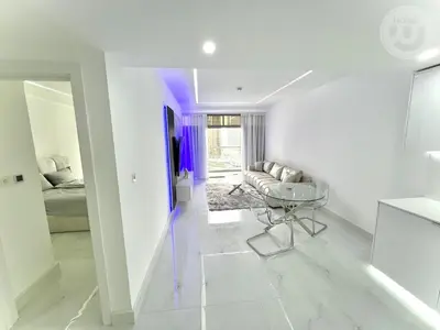 a white living room with a couch and a table at BRAND NEW luxury & modern in JLT in Dubai