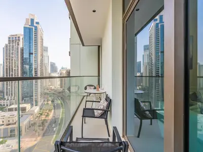 a balcony with chairs and a view of a city at the 'Paris' Condo - Stylish 2Bd with Burj View in Dubai