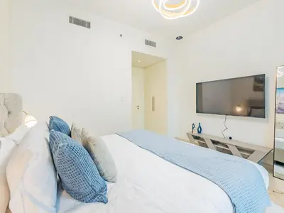 a bedroom with a bed with a tv on the wall at the 'Paris' Condo - Stylish 2Bd with Burj View in Dubai