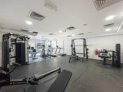 a gym with several treadmills and machines in it at Vibrant Studio with Gym Access in Dubai
