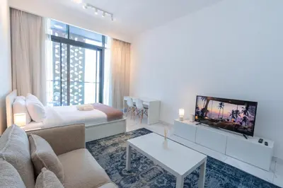 a living room with a couch and a tv at Vibrant Studio with Gym Access in Dubai