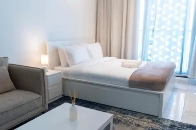 a bedroom with a bed and a couch and a table at Vibrant Studio with Gym Access in Dubai