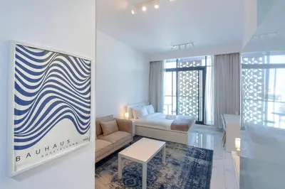 a living room with a couch and a bed in a room at Vibrant Studio with Gym Access in Dubai