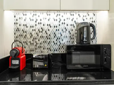 a red appliance sitting on a counter in a kitchen at Burj View 3BDR with Rooftop Infinity Pool in Dubai