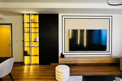 a living room with a large television on a wall at Burj View 3BDR with Rooftop Infinity Pool in Dubai