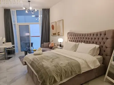 a large bedroom with a large bed and a couch at Cosy studio l close to Downtown in Dubai