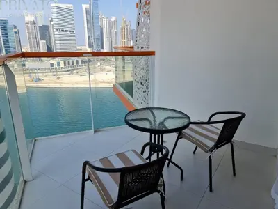 a table and chairs on a balcony with a view of the city at Cosy studio l close to Downtown in Dubai