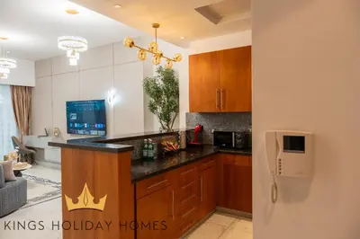 a kitchen with wooden cabinets and a counter top at Central Park Towers Royal suite DIFC Downtown in Dubai