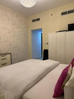 a bedroom with a large white bed and a refrigerator at Apartment in dubai in Dubai