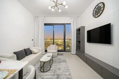 a living room with a couch and a tv at FIRST CLASS 1BR Stylish Urban Retreat in Dubai