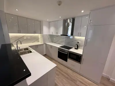 a white kitchen with a sink and a stove at 1BR Apartment JBR in Dubai