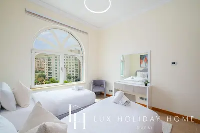 two beds in a room with a window and a sink at LUX The Shoreline Palm Island Skyline Suite 2 in Dubai