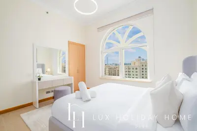 a bedroom with a white bed and a window at LUX The Shoreline Palm Island Skyline Suite 2 in Dubai
