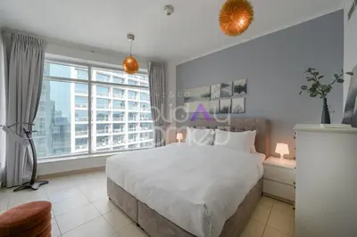 a bedroom with a large bed and a large window at Modern 1BR in Burj Views Tower Downtown in Dubai