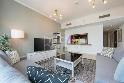 a living room with a couch and a tv at Modern 1BR in Burj Views Tower Downtown in Dubai