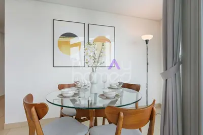 a dining room with a glass table and chairs at Modern 1BR in Burj Views Tower Downtown in Dubai