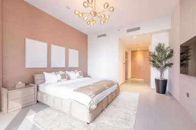 a bedroom with a large bed and a chandelier at Luxury 4BR with Hermes Touch & Burj Khalifa View in Dubai