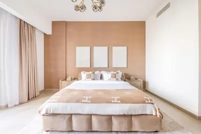 a large bedroom with a large bed with a chandelier at Luxury 4BR with Hermes Touch & Burj Khalifa View in Dubai