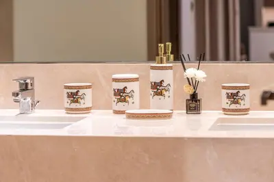 a bathroom counter with a sink with four bottles and a sink at Luxury 4BR with Hermes Touch & Burj Khalifa View in Dubai