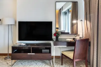 a hotel room with a desk with a television on it at Luxury Studio in Emaar Residence Fashion Avenue in Dubai