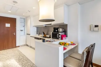 a kitchen with white counters and a counter top at Luxury Studio in Emaar Residence Fashion Avenue in Dubai