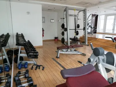 a gym with several exercise equipment in a room at Bright studio with new furniture in Dubai