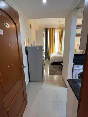a small kitchen with a refrigerator and a bedroom at MarinaBliss in Dubai