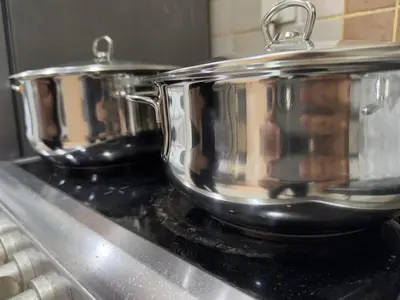 two pots sitting on top of a stove at Spacious Studio in Dubai Sports City in Dubai