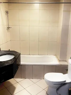 a bathroom with a sink and a toilet and a tub at Spacious Studio in Dubai Sports City in Dubai
