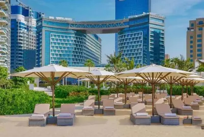 a beach with chairs and umbrellas in front of buildings at 7 palm Jumeirah one bedroom in Dubai