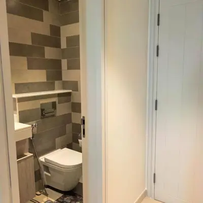 a bathroom with a toilet and a tile wall at 7 palm Jumeirah one bedroom in Dubai