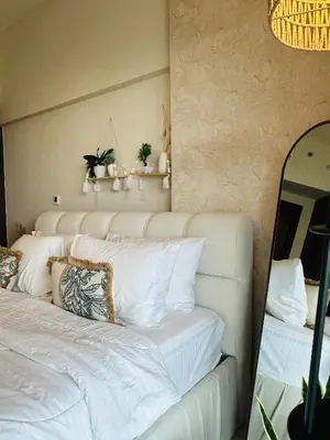 a bedroom with a bed with white sheets and a mirror at Boho 2bhk near Dubai mall with best nightlife in Dubai
