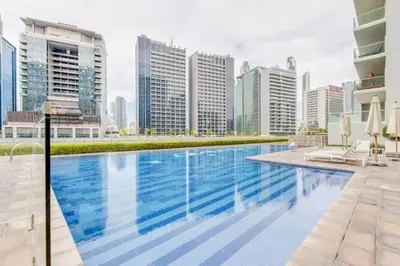 a large swimming pool in a city with tall buildings at Boho 2bhk near Dubai mall with best nightlife in Dubai